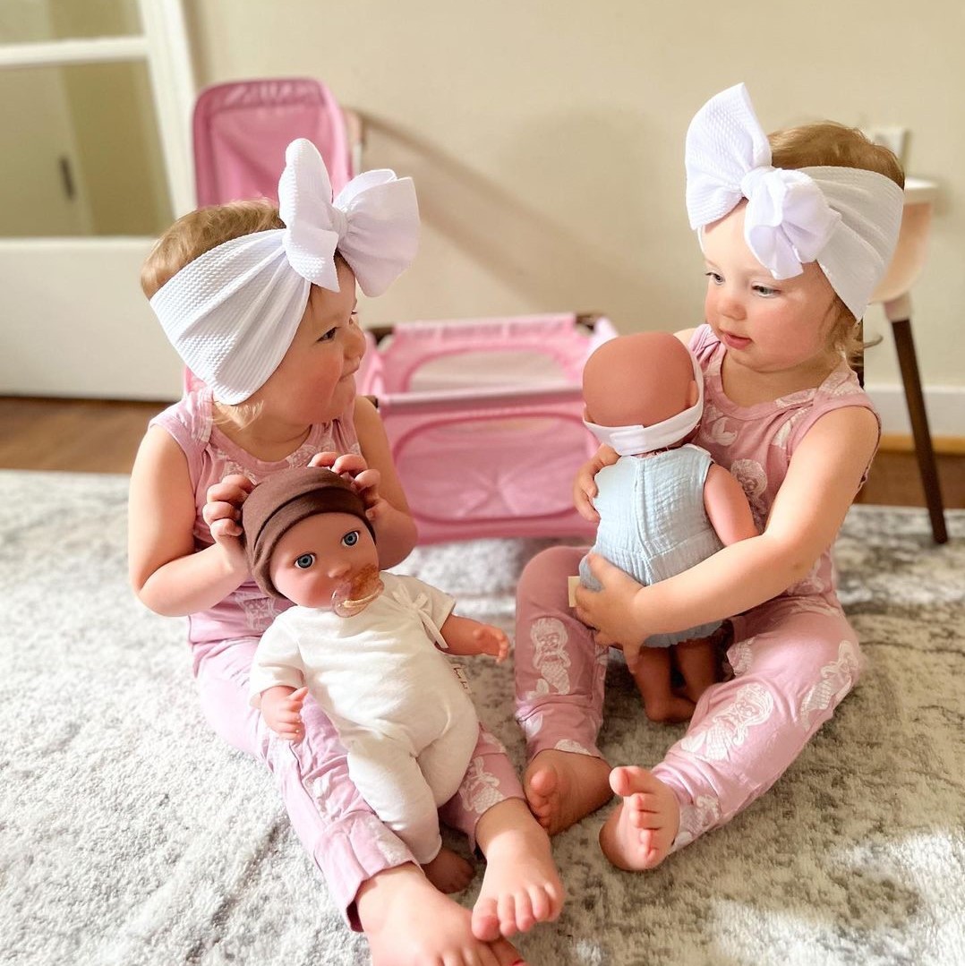 children playing with LullaBaby dolls with pink playpen and accessories