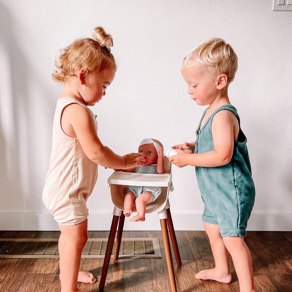 boy and girl feed baby doll in LullaBaby high chair