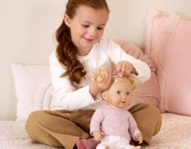 Girl brushing Lullababy doll's blonde wavy hair